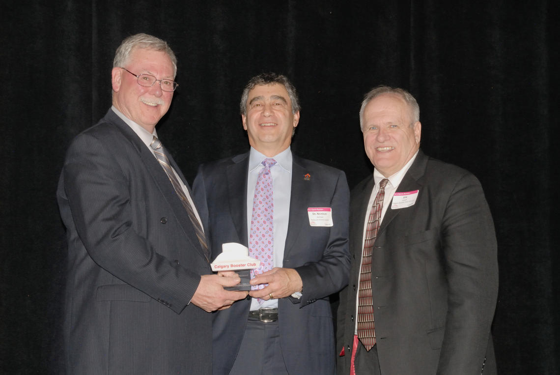 Nick Mohtadi, centre, receives an award from Calgary Booster Club’s Al Taylor, right, and Jon Jewell.