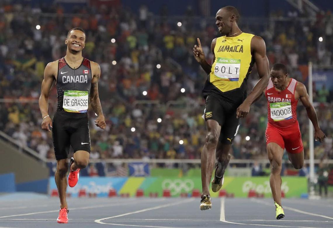 Jamaica’s Usain Bolt, right, gestures towards Canada’s Andre De Grasse after the finish of the men’s 200-meter semifinal.