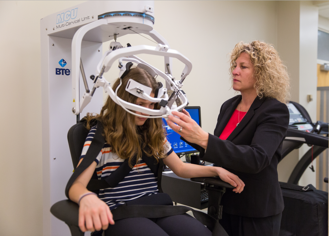 Dr. Kathryn Schneider examines a girl for concussion.