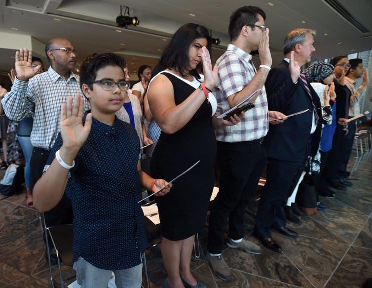 New census data gives insight into Canada’s immigrant population, including how English language proficiency can impact wages. Here, a group of new Canadians take part in a citizenship ceremony in Ottawa in September.