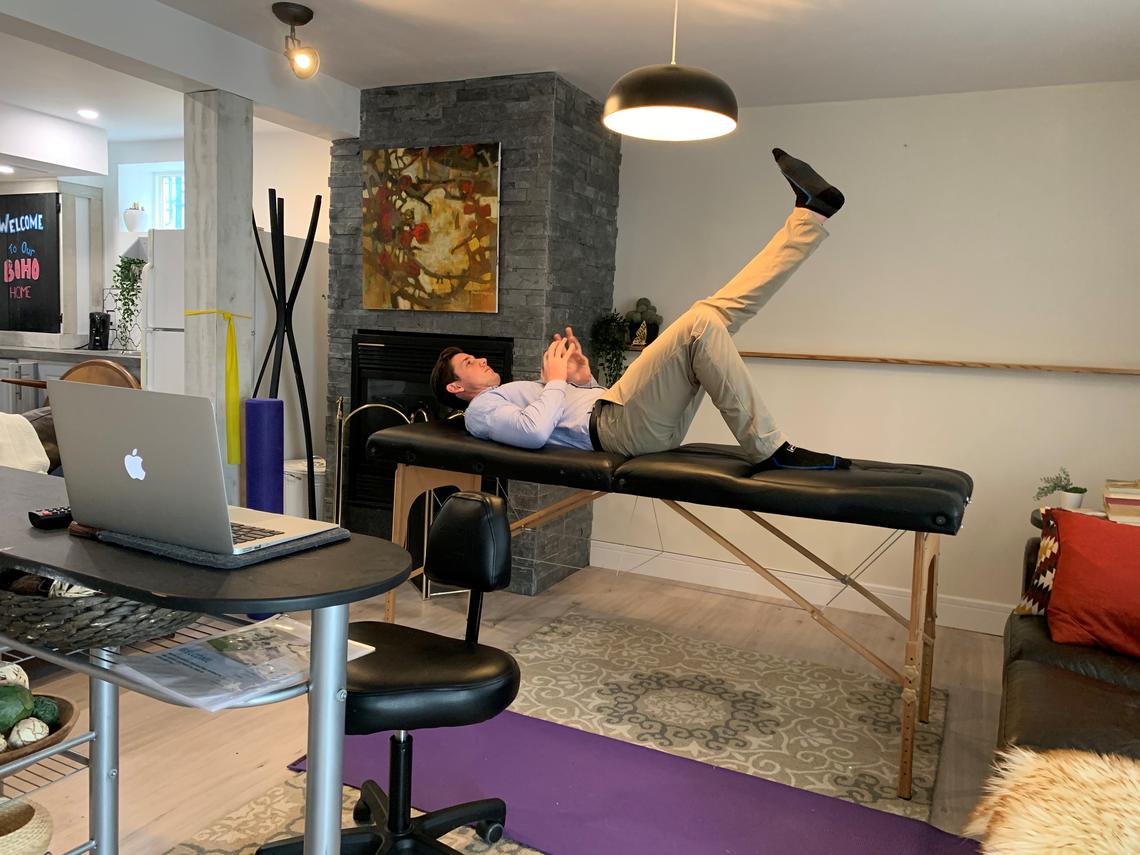 Brett Henderson demonstrates an exercise in his living room.