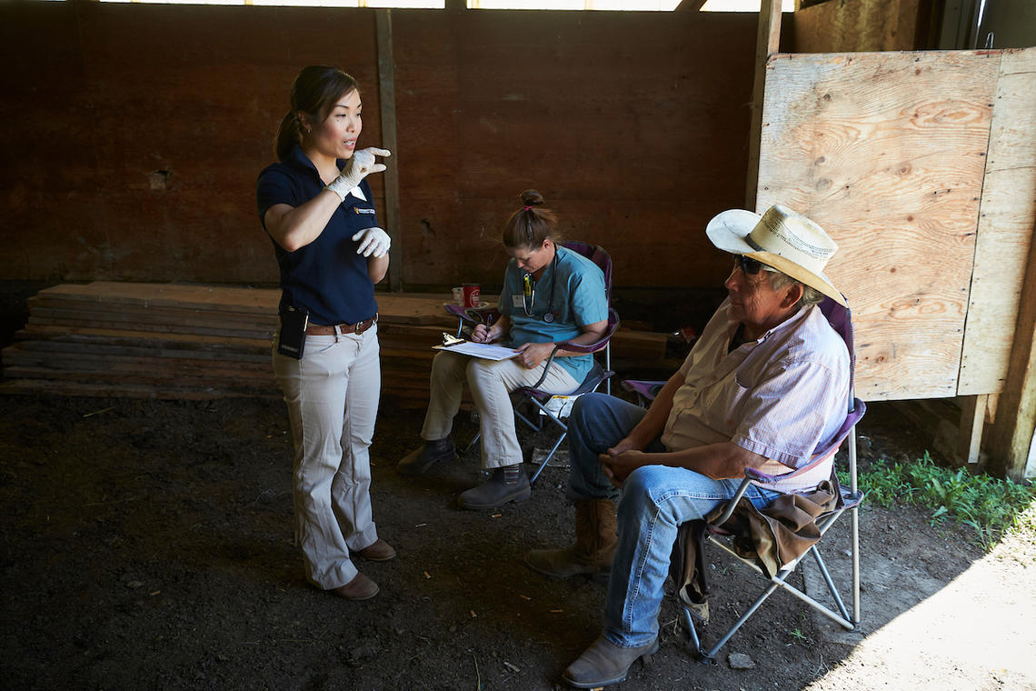 Dr. Tan speaks with horse owner Marvin Dodginghorse during a 2019 equine rotation. 