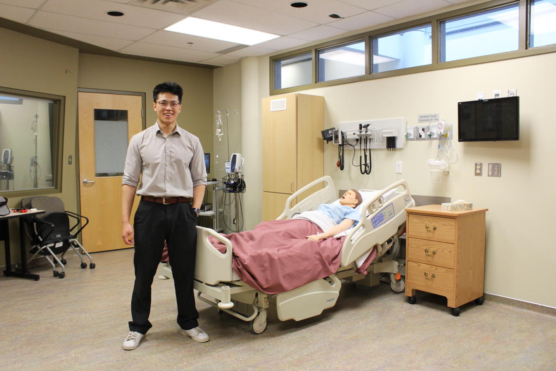 Luu stands in the actual sim suite at UCalgary Nursing's Clinical Simulation Learning Centre that he replicated in his VR model.