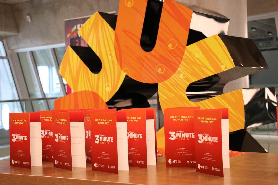 Red 3MT programs on display in front of a large, 3 dimensional UCalgary spark