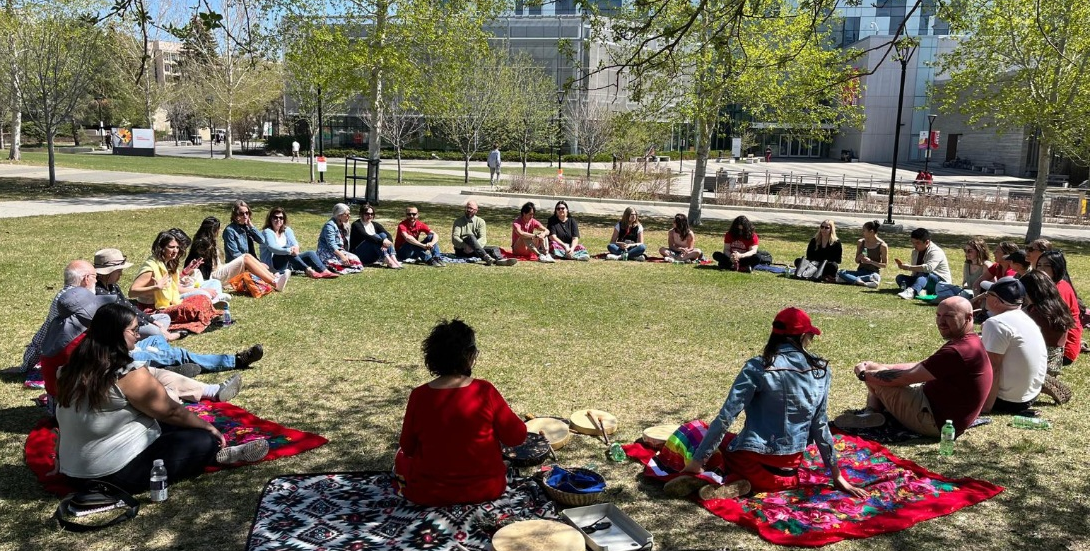 people sitting in a circle on a lawn outdoors