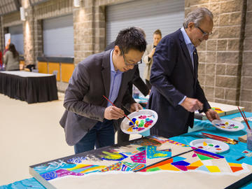 Andrew Szeto, director of the Campus Mental Health Strategy, and Frank O’Dea work on a collaborative mural for the Campus Community Hub, facilitated by Jaclynn Phillips from Prospect Studio C.