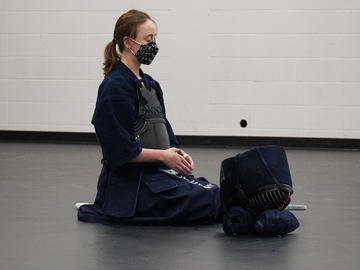 A student meditates before beginning a Kendo class.