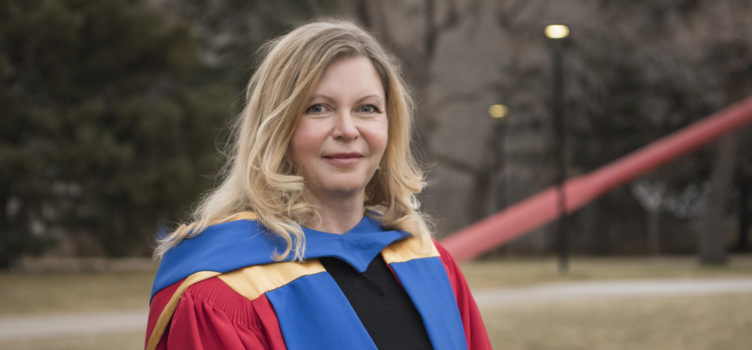 Dr. Marina L. Gavrilova wearing a blue, red, and yellow PhD robe.