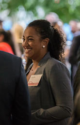 A Black female smiles in a crowd of people