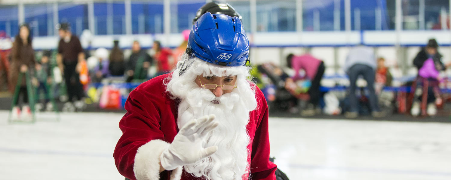 An image of a helmet-wearing Santa skating and waving and a child 