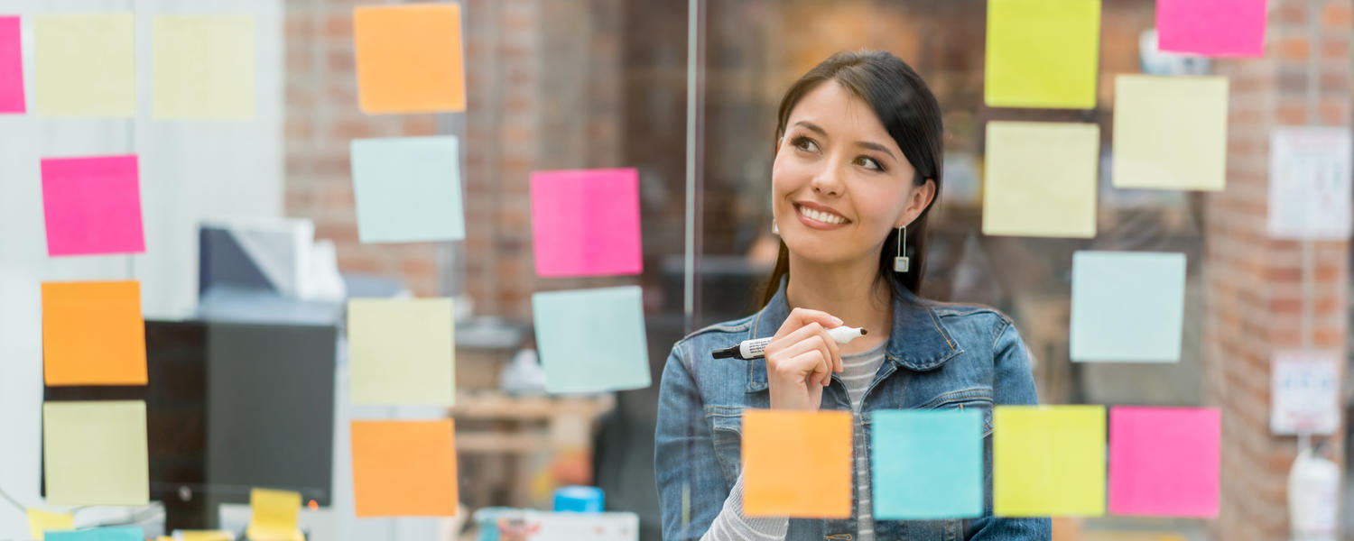 person behind a plexi wall with post-it notes