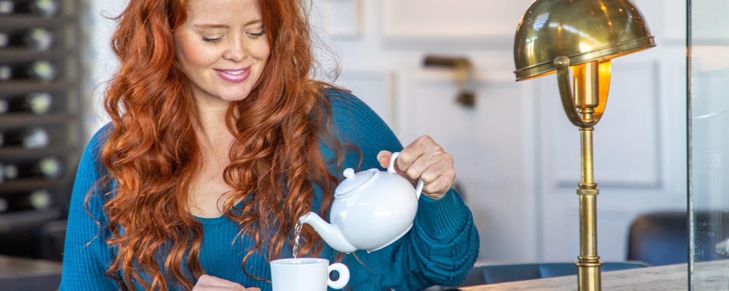 A woman pouring a cup of tea