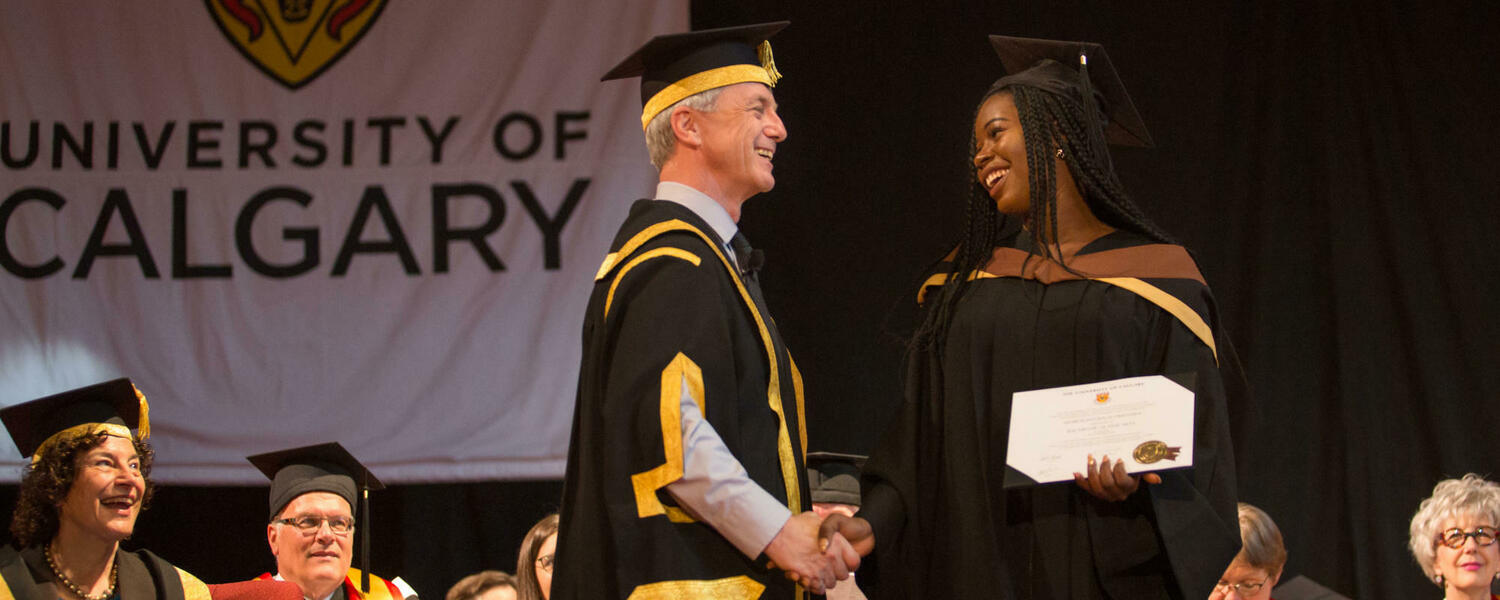 A graduate receives a degree on stage during convocation