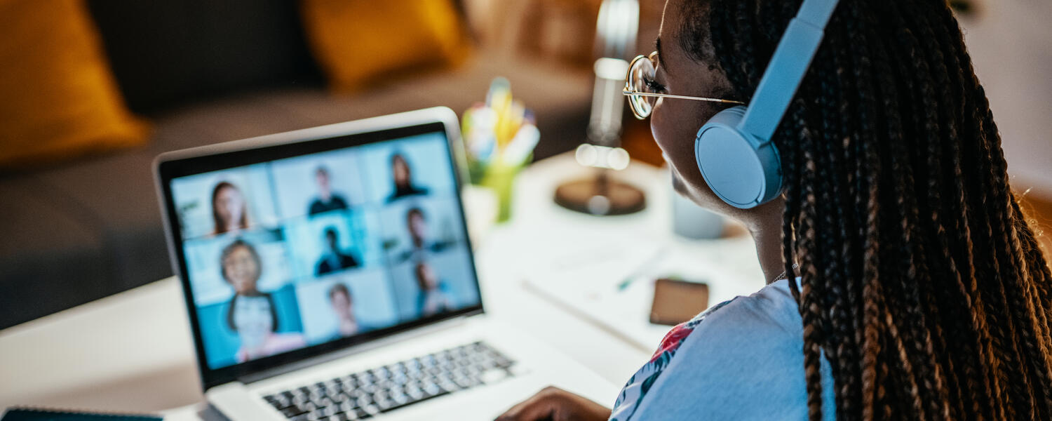 An image of a person at a laptop with headphones on