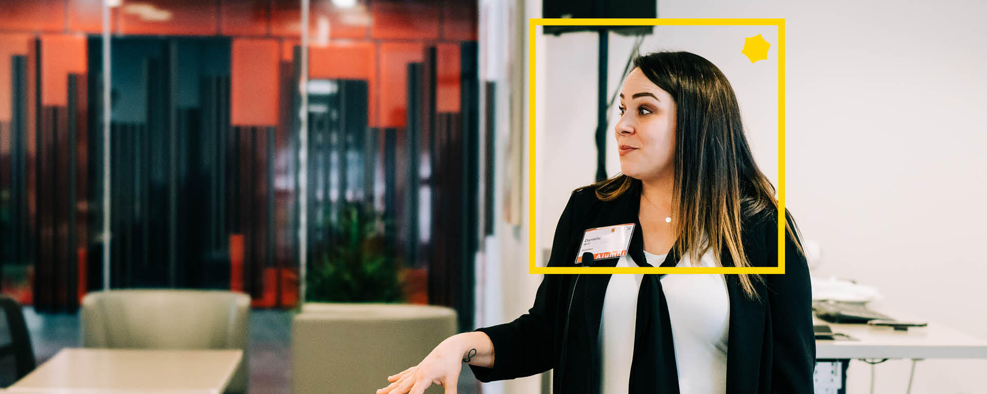 A woman in a classroom setting with a yellow alumni box around her face.