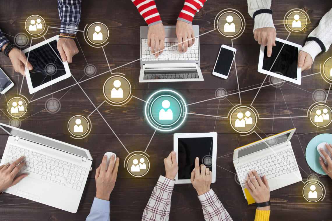 A group of people's hands on laptops networking