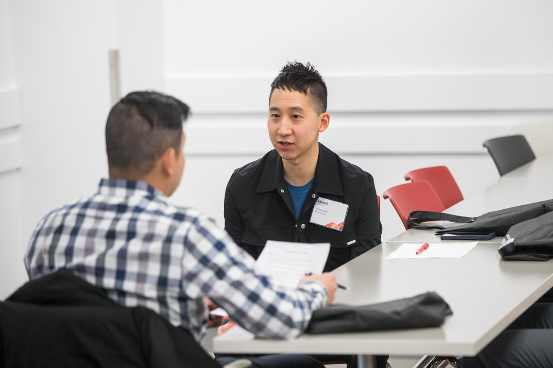 a photo of two men sitting at a table reviewing a resume at last year's Grow Your Career Conference.