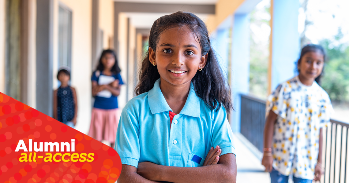 A image of a girl smiling into the camera. She is wearing a blue shirt. 