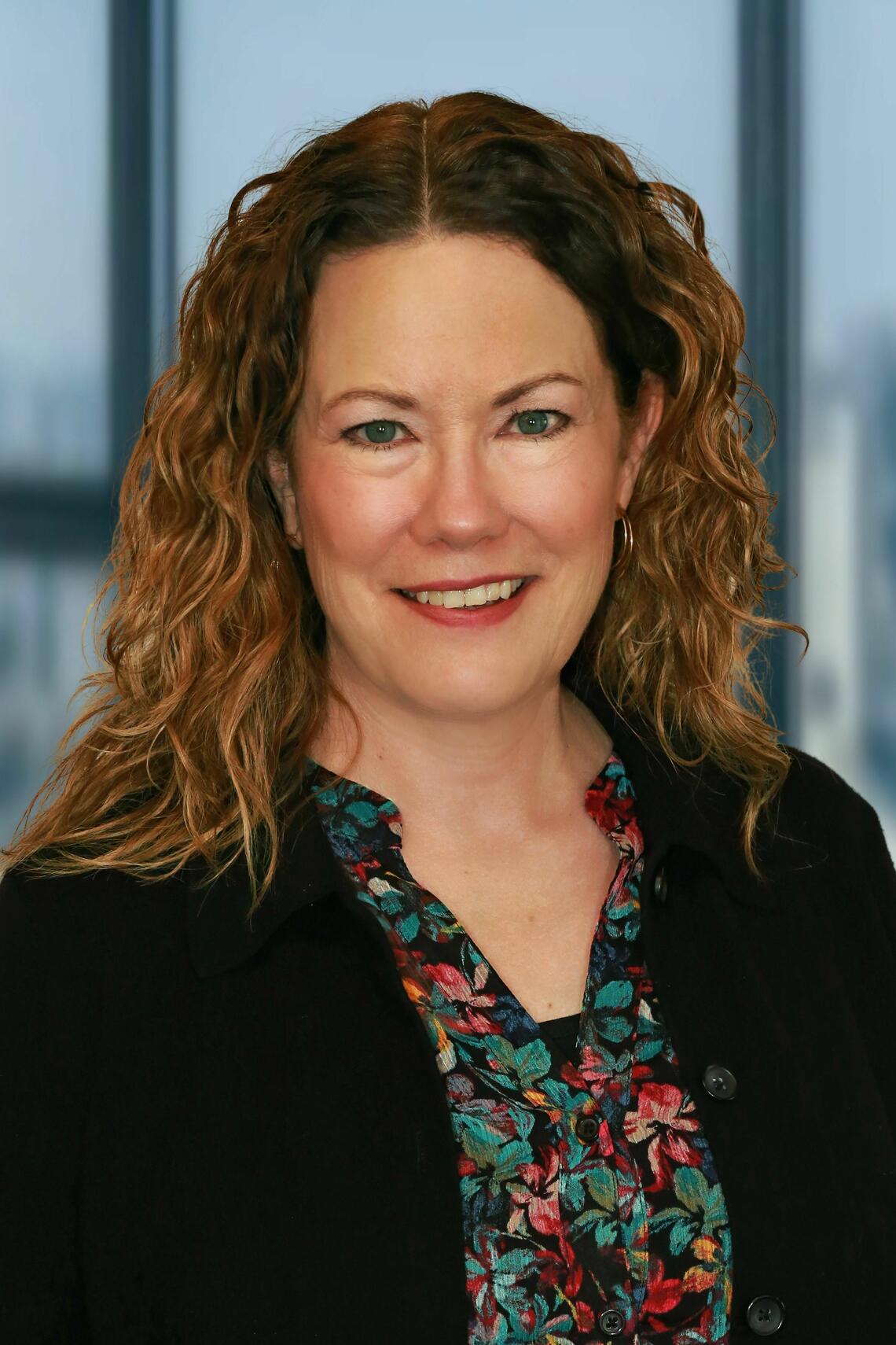 Jill Nikiforuk wearing a black blazer and colourful shirt.