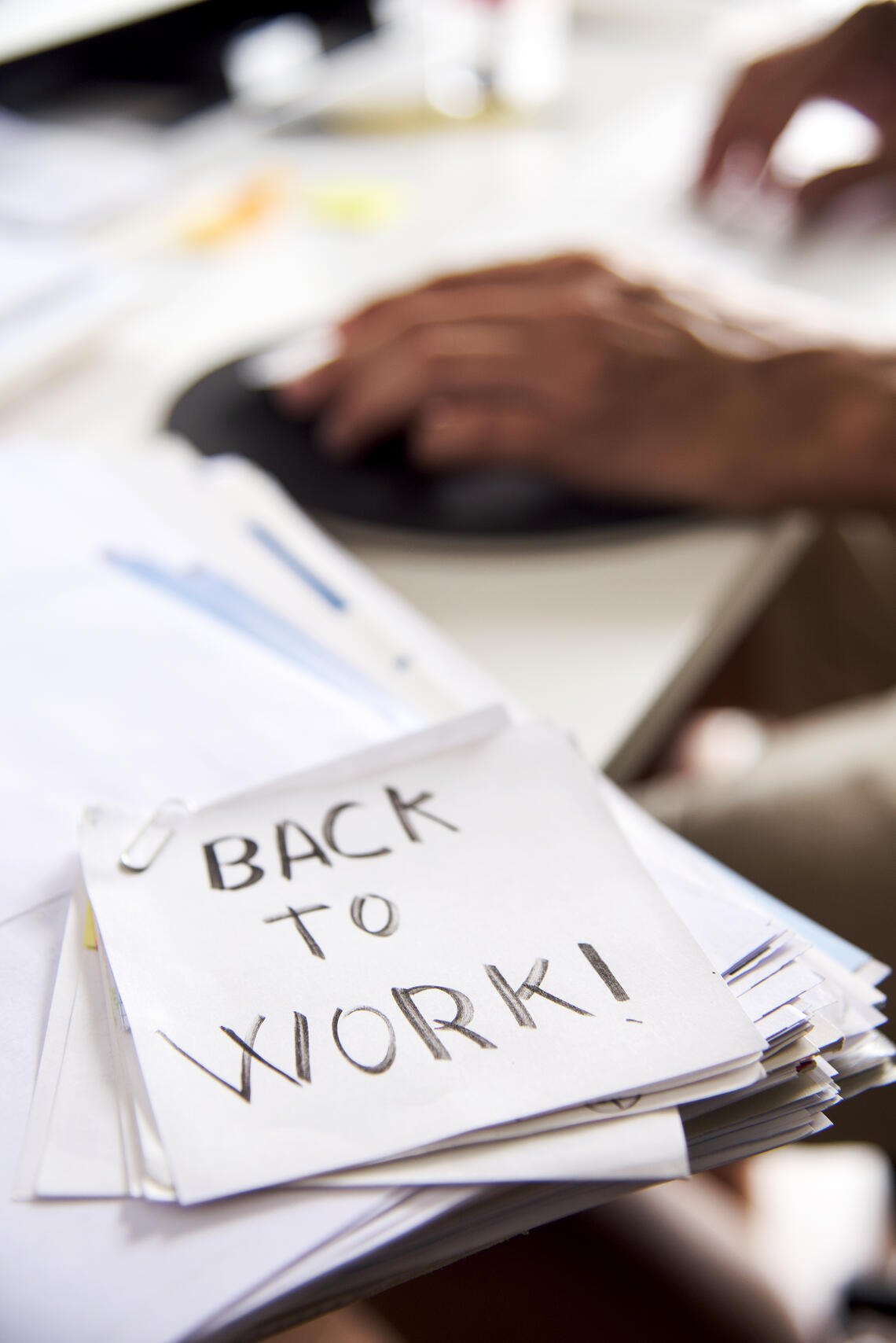 A photo of a note on a desk that reads "Back to Work!" 