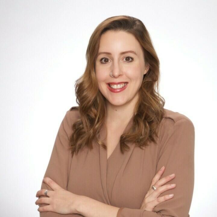 A photo of Jennifer wearing a brown blouse in front of a white background.