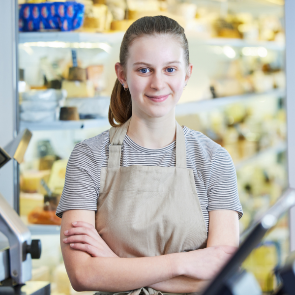 girl wearing an apron working at a grocery store