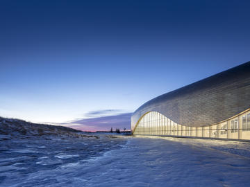 Copper/zinc panels clad the exterior and reflect the prairie light.