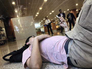 Fellow injured passenger, Wang Lei, lies on the floor of Yangon International Airport, waiting for treatment.