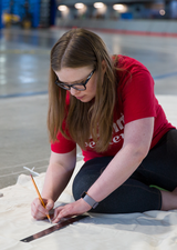 woman drawing on a large canvas
