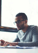 Man working on laptop in front of window