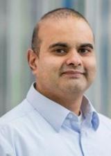 Portrait of Ashu Gandhi wearing a light grey shirt