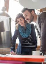 An image of two individuals looking at a computer screen