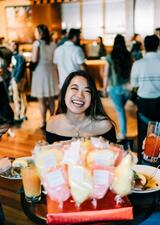 Young women smile and laugh at a table at a social event