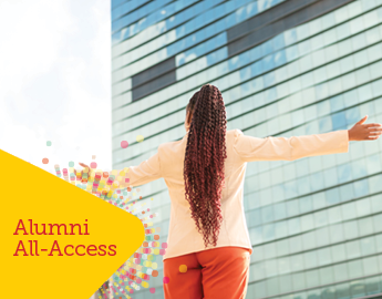 woman standing with her hands out in front of a glass building with all access tag