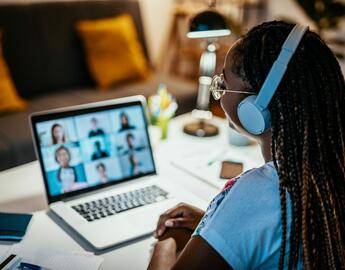 An image of a person at a laptop with headphones on