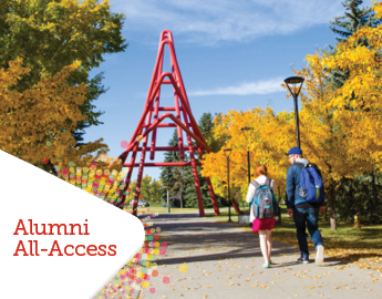 The University of Calgary red paperclip statue. two people walk towards it on a fall day.