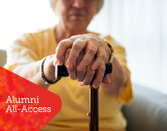 An elderly person's hands holding a cane.